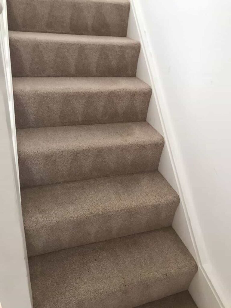 This is an after photo of a staircase with a beige carpet that has been cleaned.